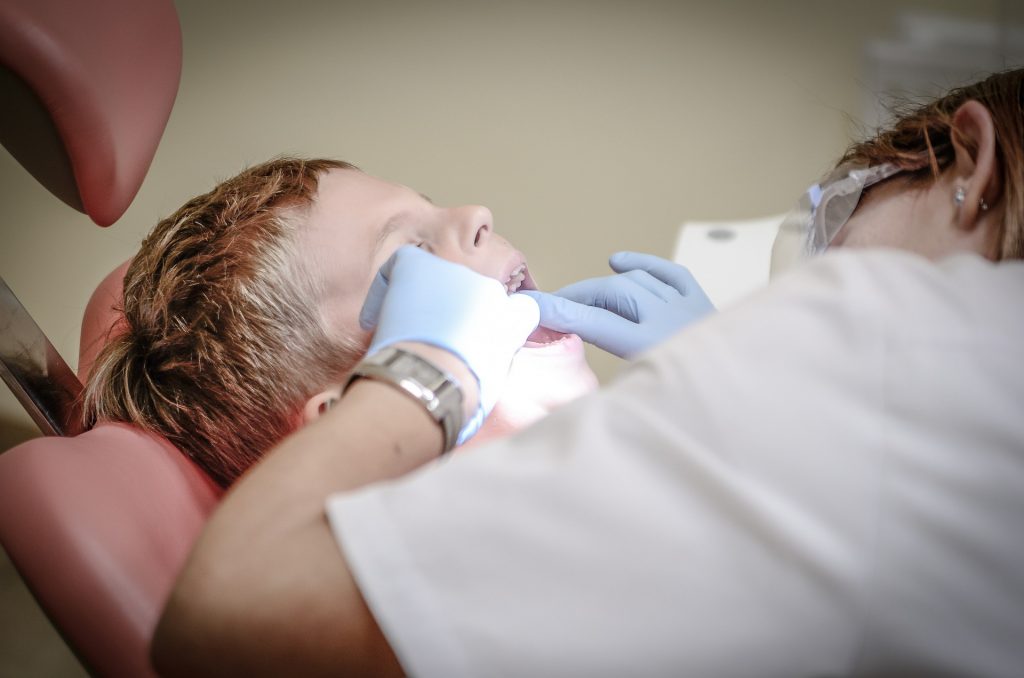 Dentiste qui regarde les dents d'un enfant