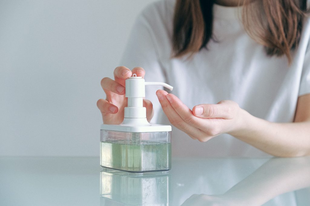 Jeune femme qui se lave les mains avec du gel hydroalcoolique